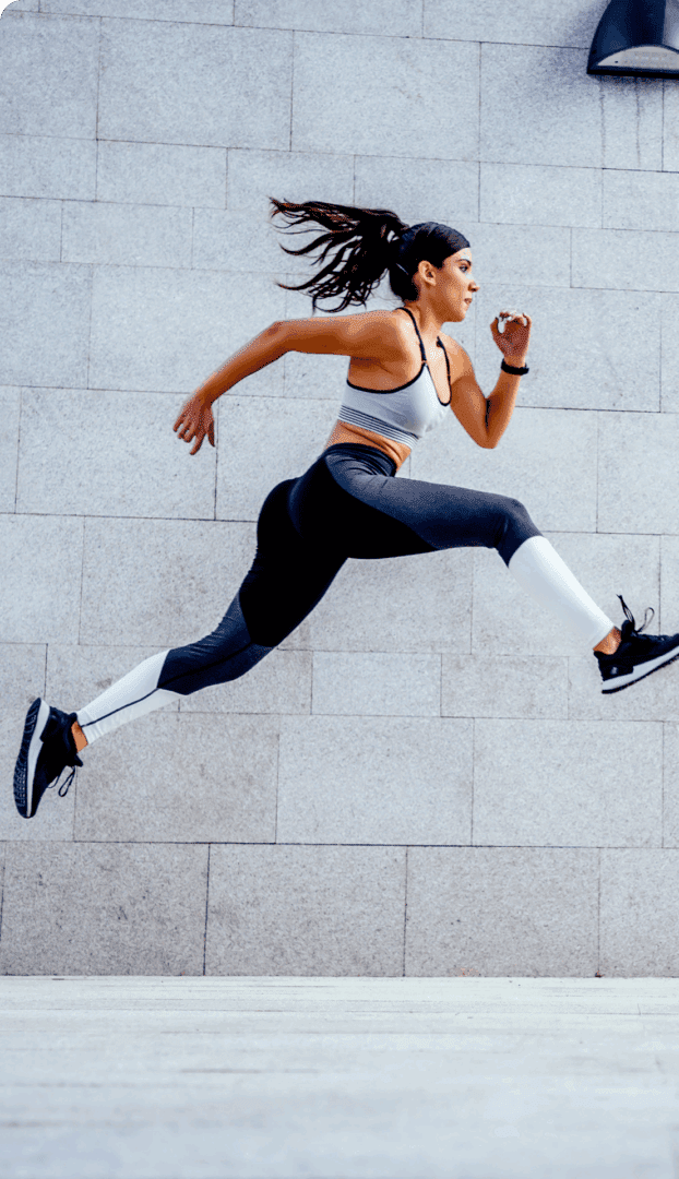 Fitness enthusiast leaping on pavement